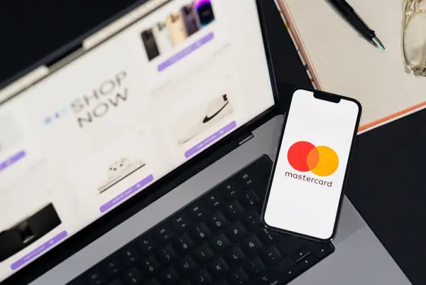 Smartphone showing the Mastercard logo resting on a laptop keyboard