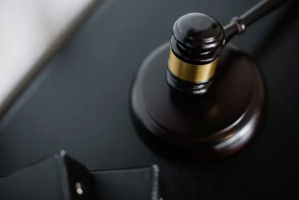 Wooden judge's gavel on a courtroom table near case folders