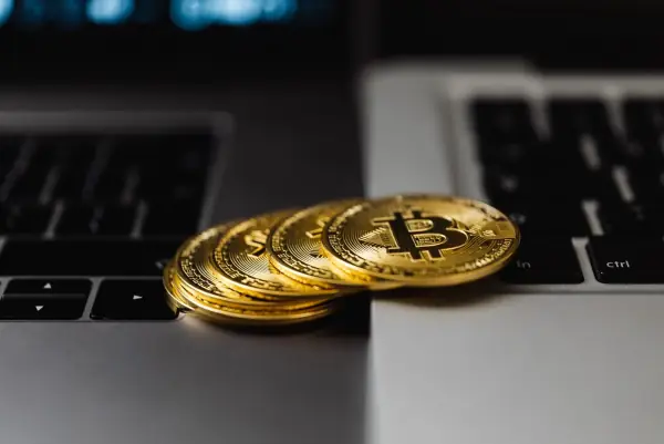 Gold bitcoin coins resting on laptop keyboards